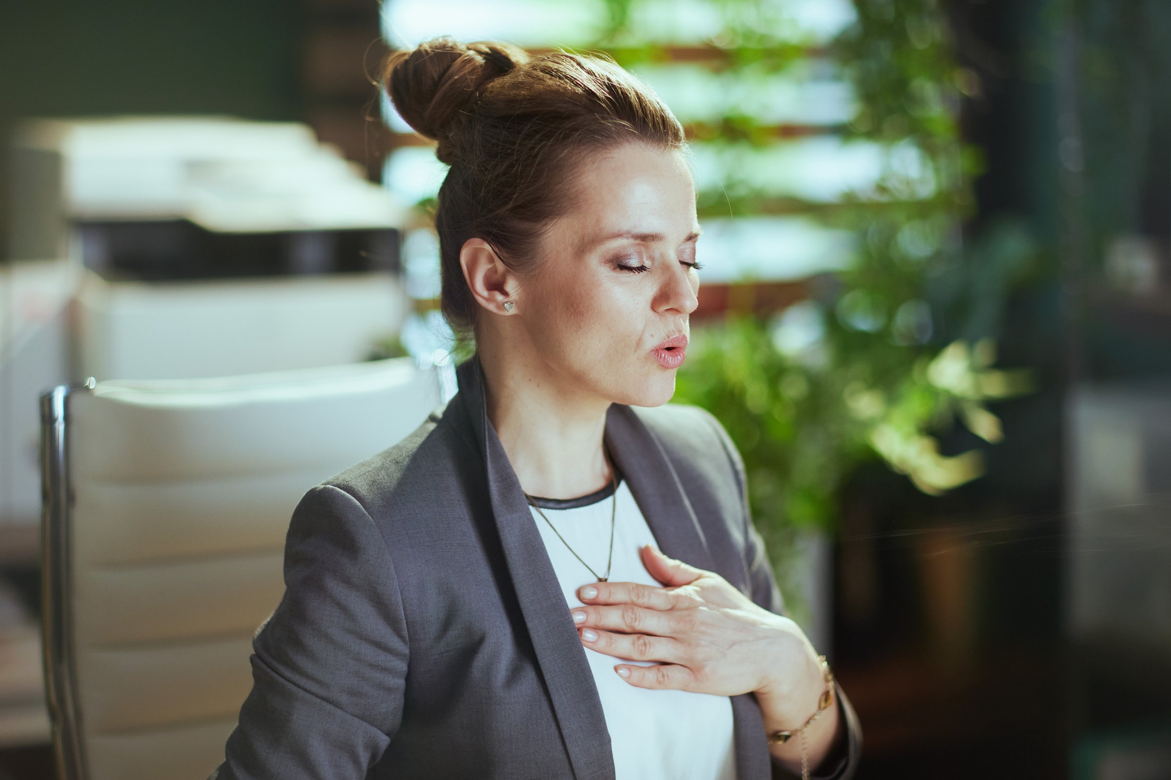 business owner woman in green office doing breathing exercises